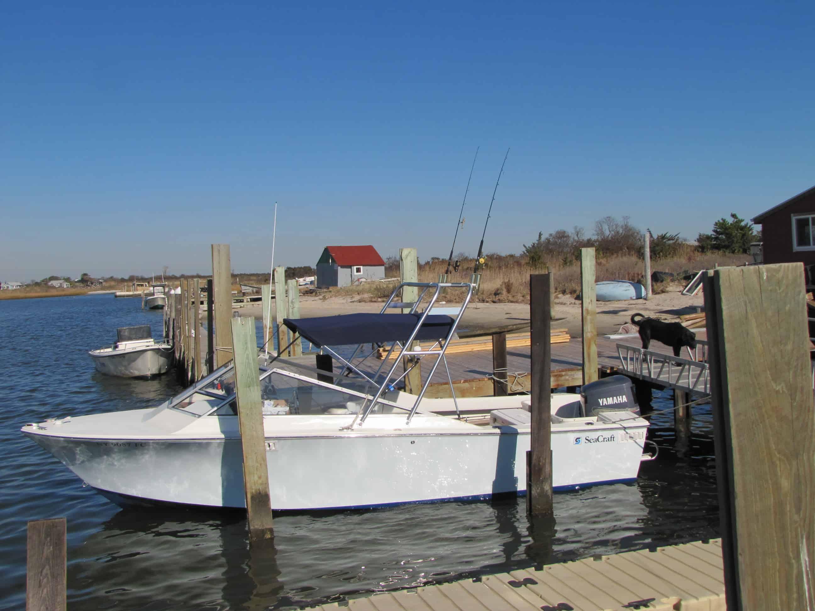 Atlantic Towers Top installed on a boat docked near wooden pilings in a calm waterway under a clear blue sky.