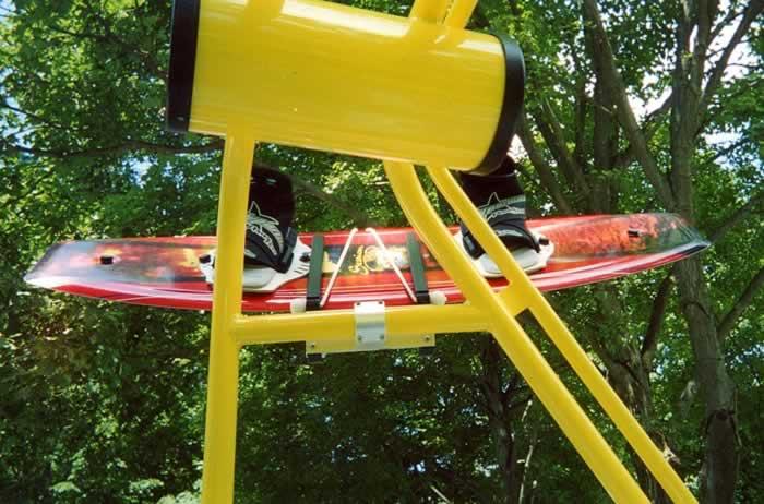 Atlantic Towers accessories mounted with water skis, showcasing a bright yellow support structure and green foliage in the background.