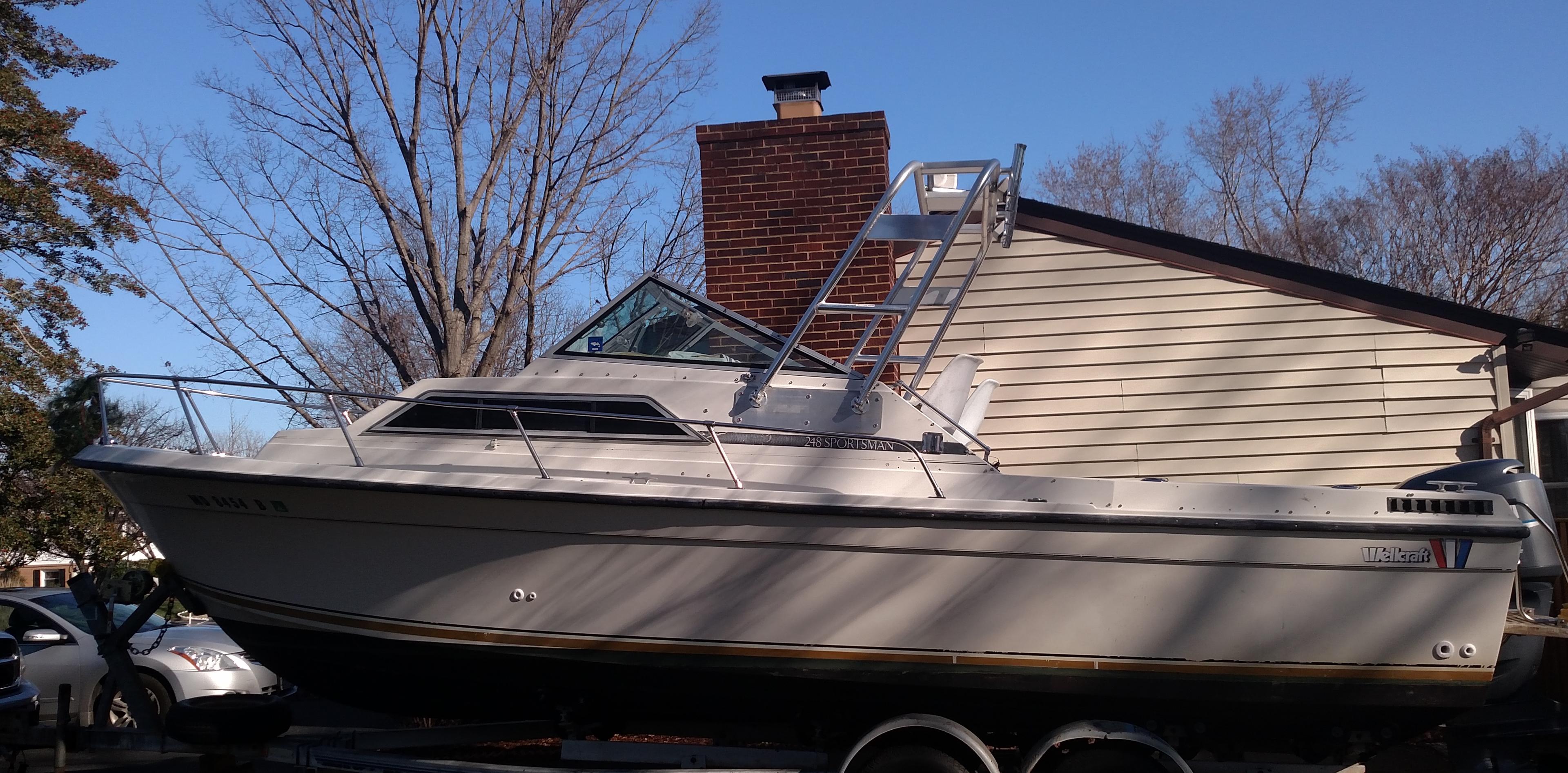 Wellcraft boat on trailer with installed Atlantic Towers Arch mounted behind the cabin under clear sky background