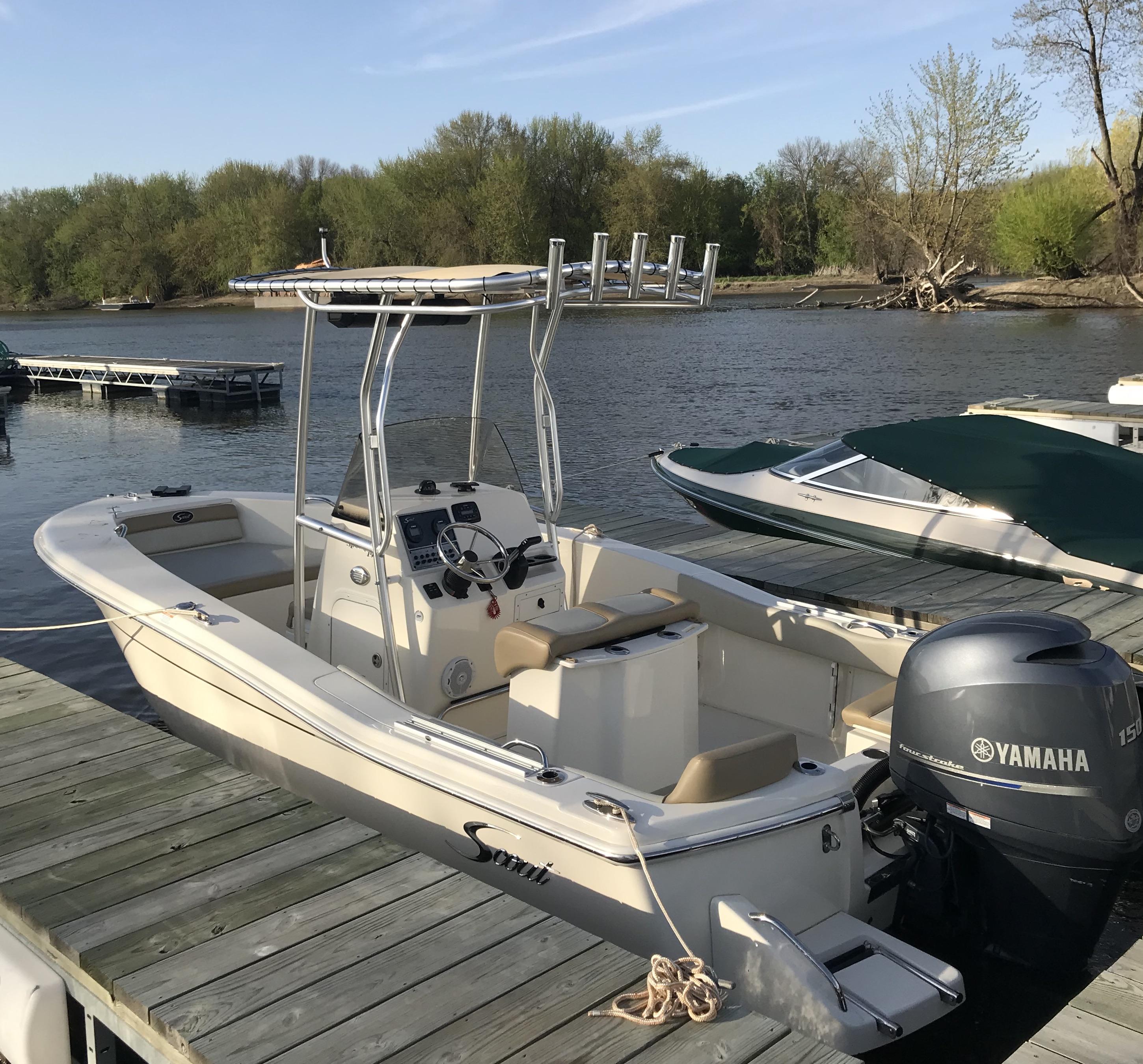 Atlantic Towers T-Top installed on a Scout boat at a dock beside a calm river, with greenery in the background.
