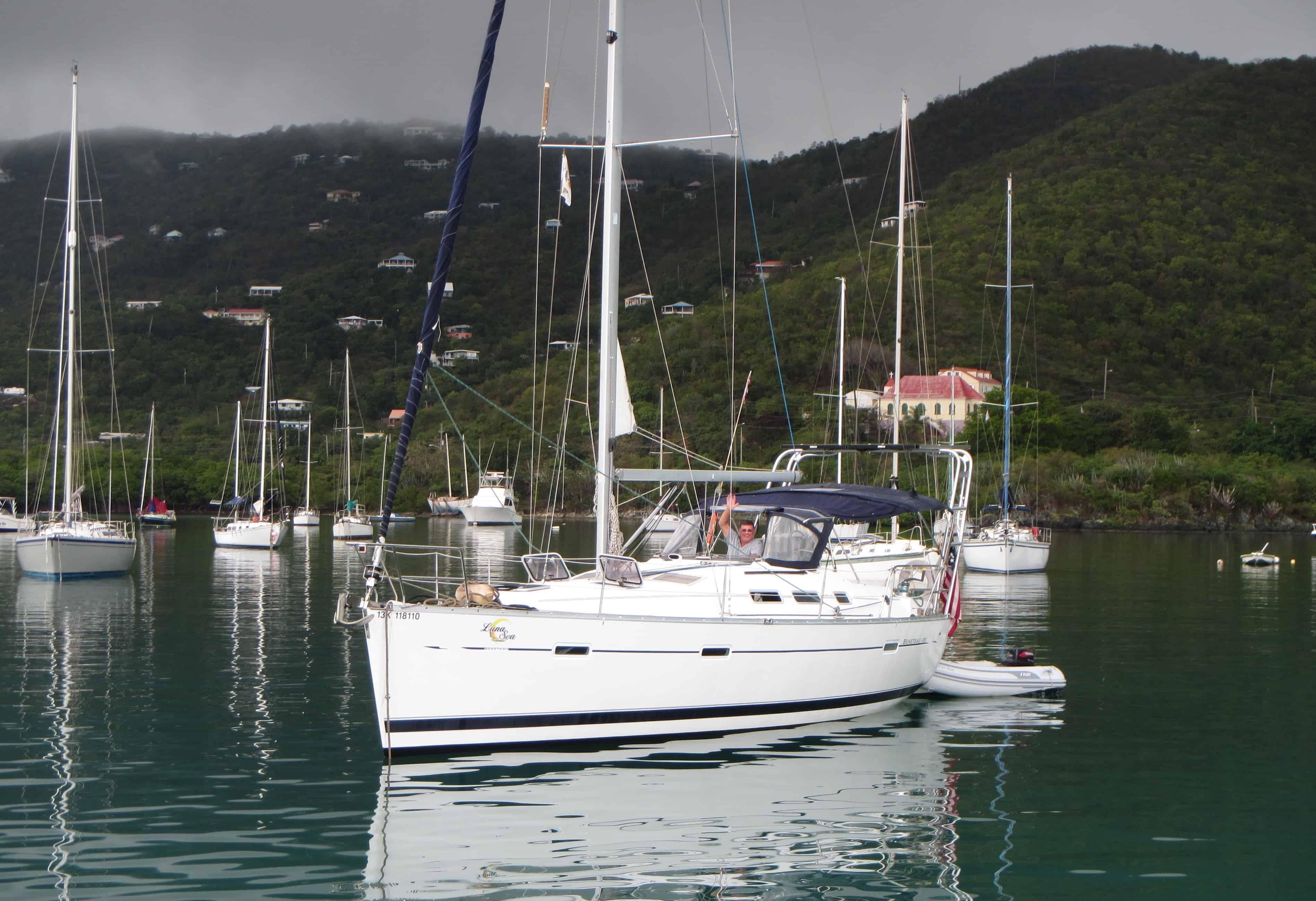 Atlantic Towers Arch installed on a sailboat at anchor in a calm marina, surrounded by other boats and greenery.