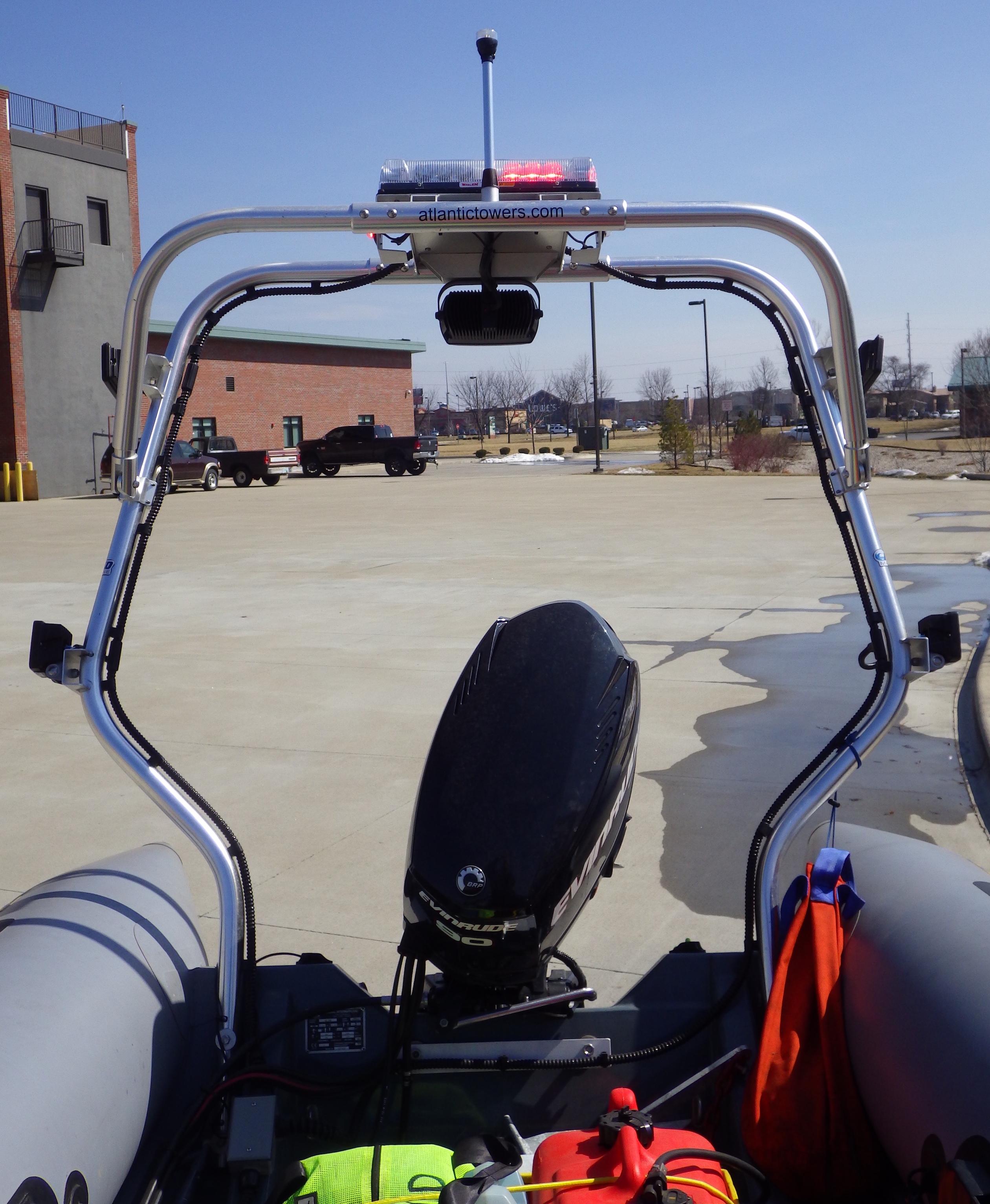 Atlantic Towers Arch installed on a Zodiac boat, showing a motor and safety gear in a parking lot.