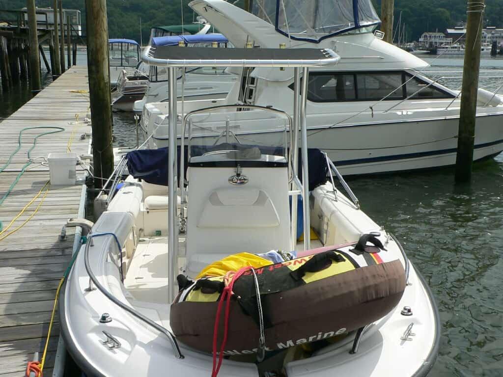 Atlantic Towers T-Top installed on a boat docked at a marina, with nearby boats and a wooden pier visible.