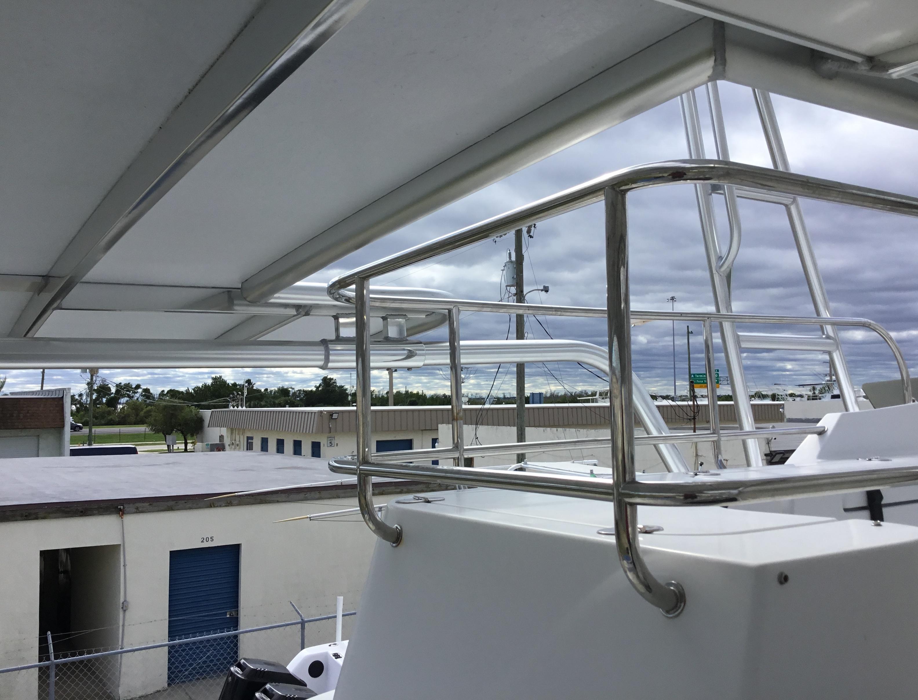 Atlantic Towers Cockpit Sun Shade installed on a boat, with a view of nearby buildings and overcast skies.