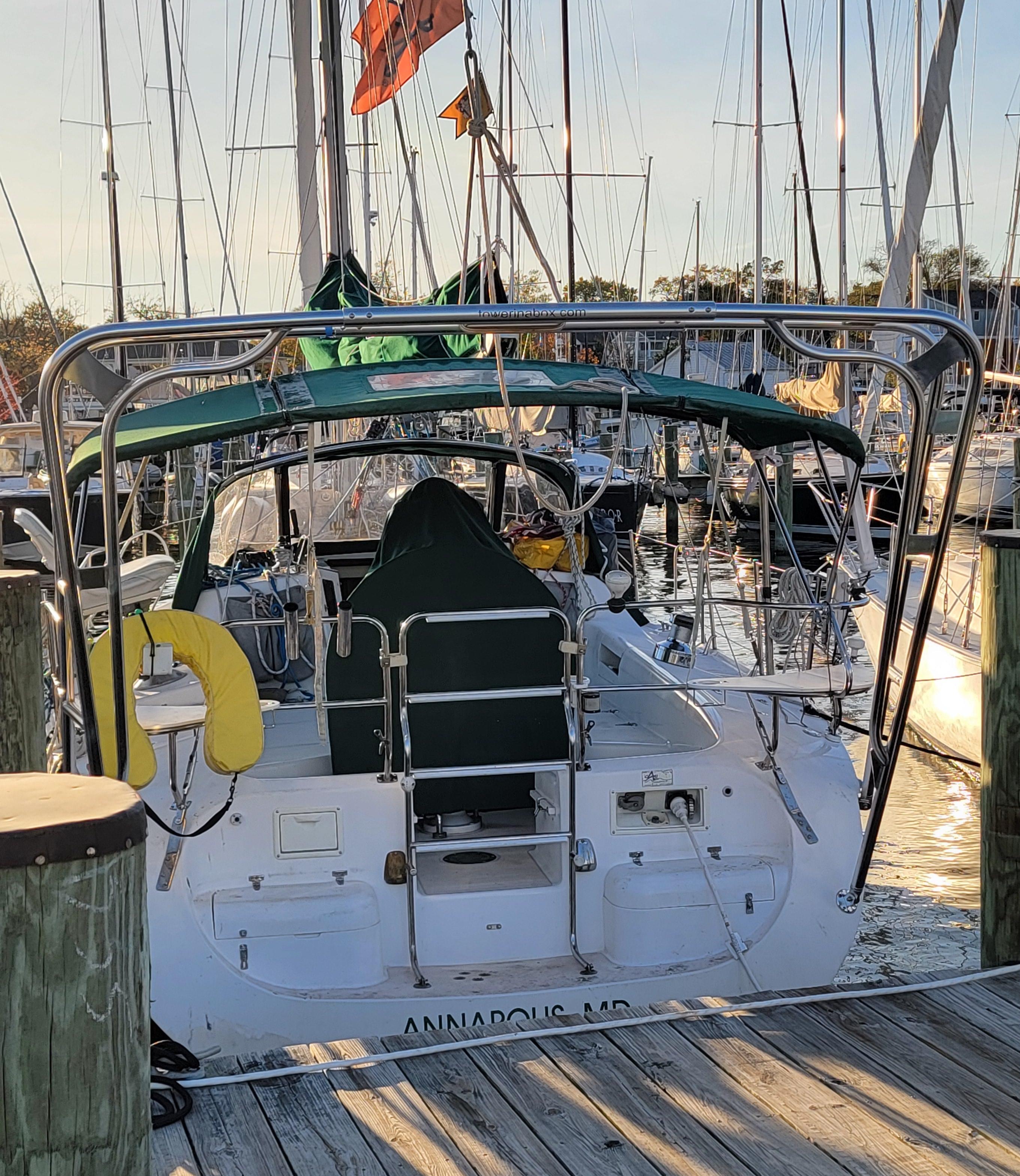 Stern view of a Catalina sailboat with installed Atlantic Towers Arch and dockside marina background at sunset.