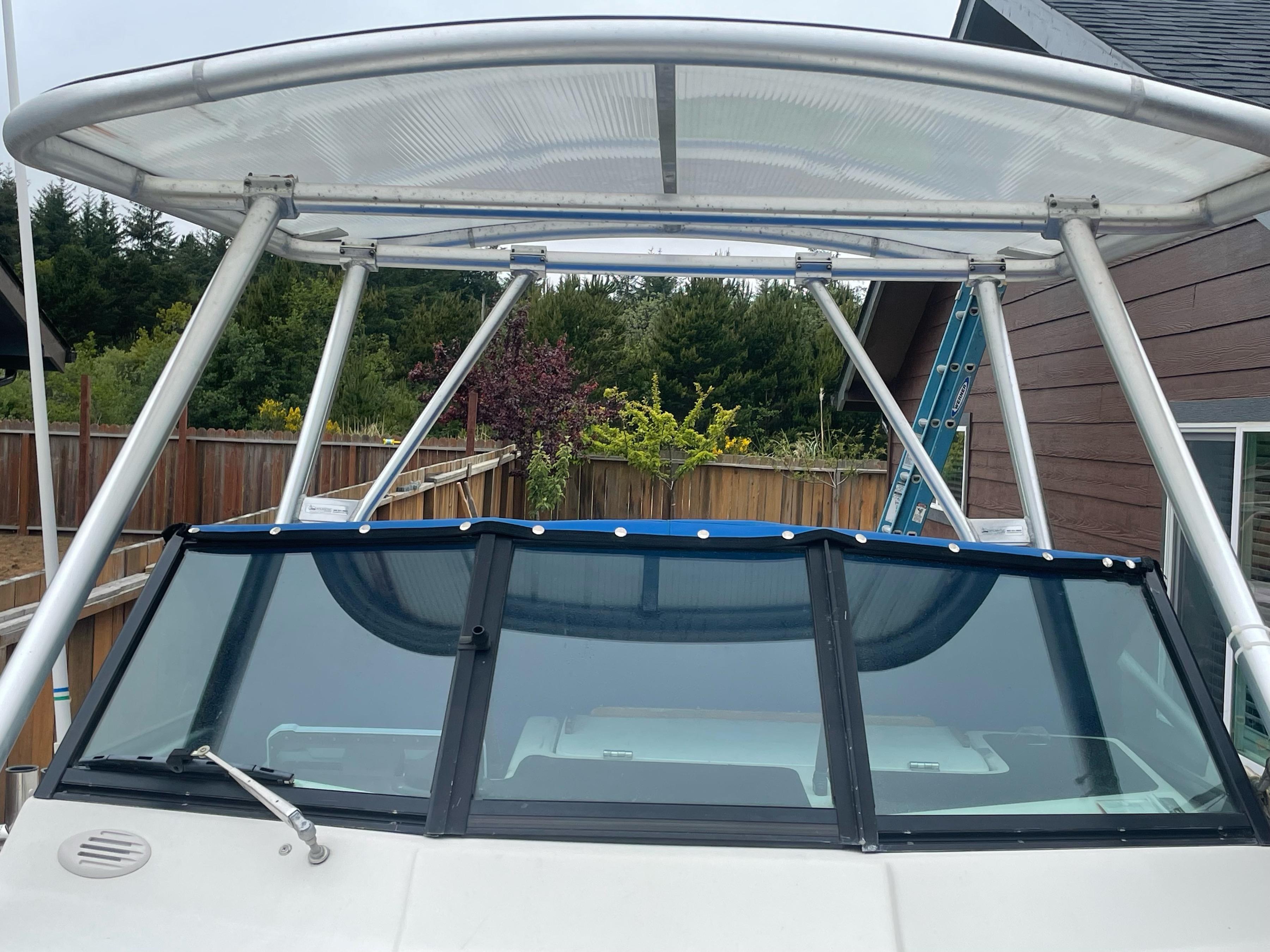 Front view of a boat with an installed Atlantic Towers Top aluminum frame and translucent canopy roof above the windshield.