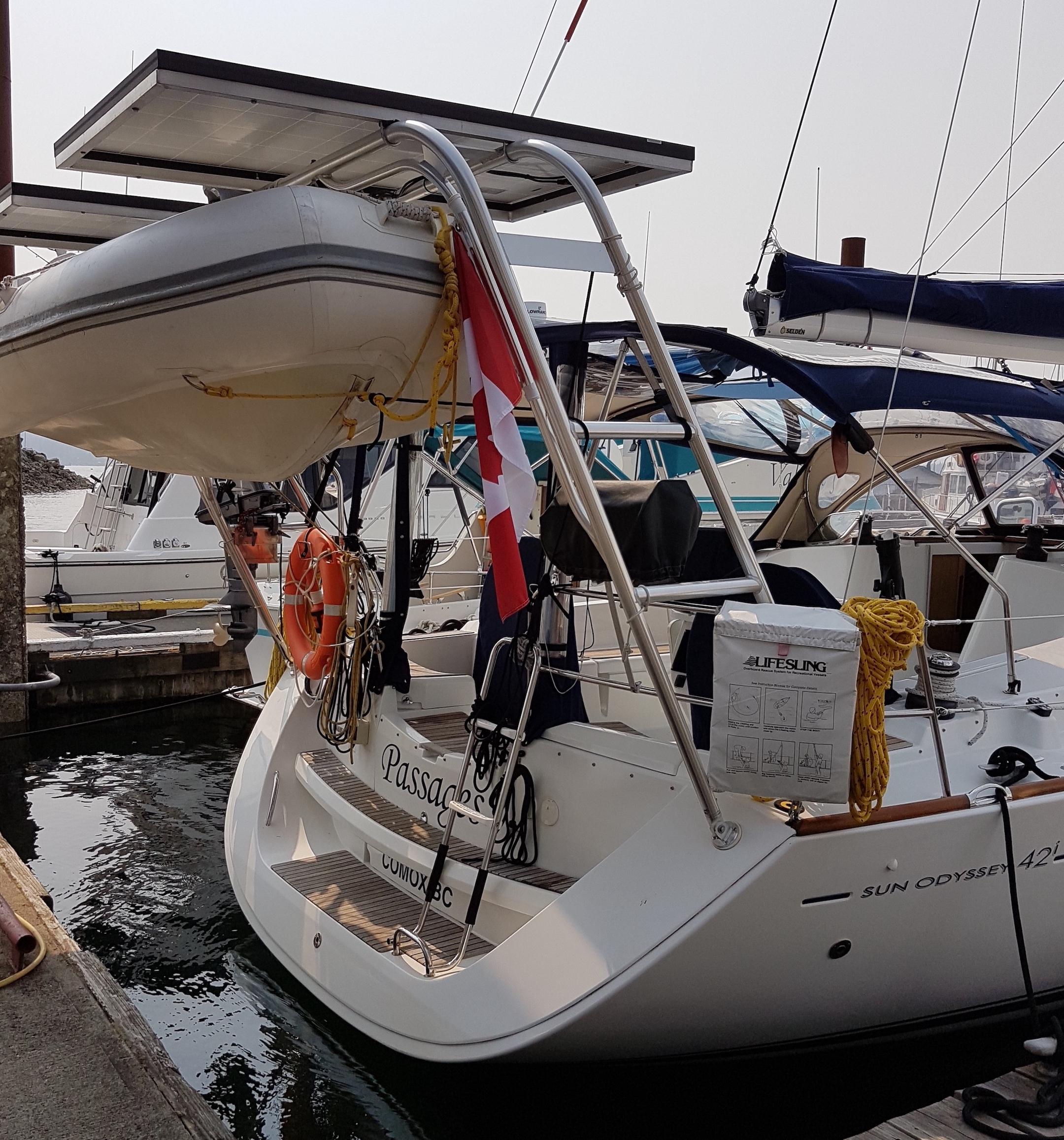 Atlantic Towers Arch installed on a Jeanneau sailboat, with a dinghy and solar panel above at the marina.