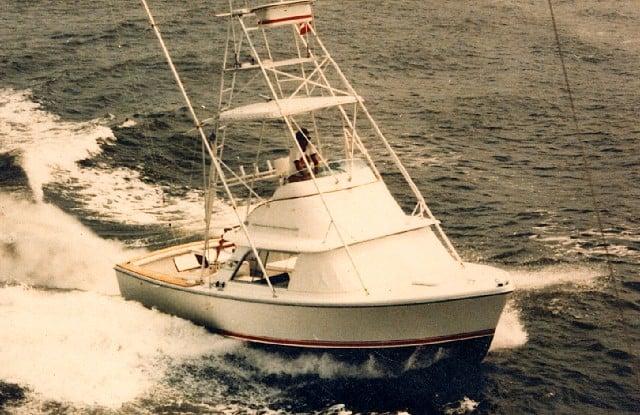 Atlantic Towers Tuna Tower installed on a Bertram boat, navigating through ocean waves under clear skies.