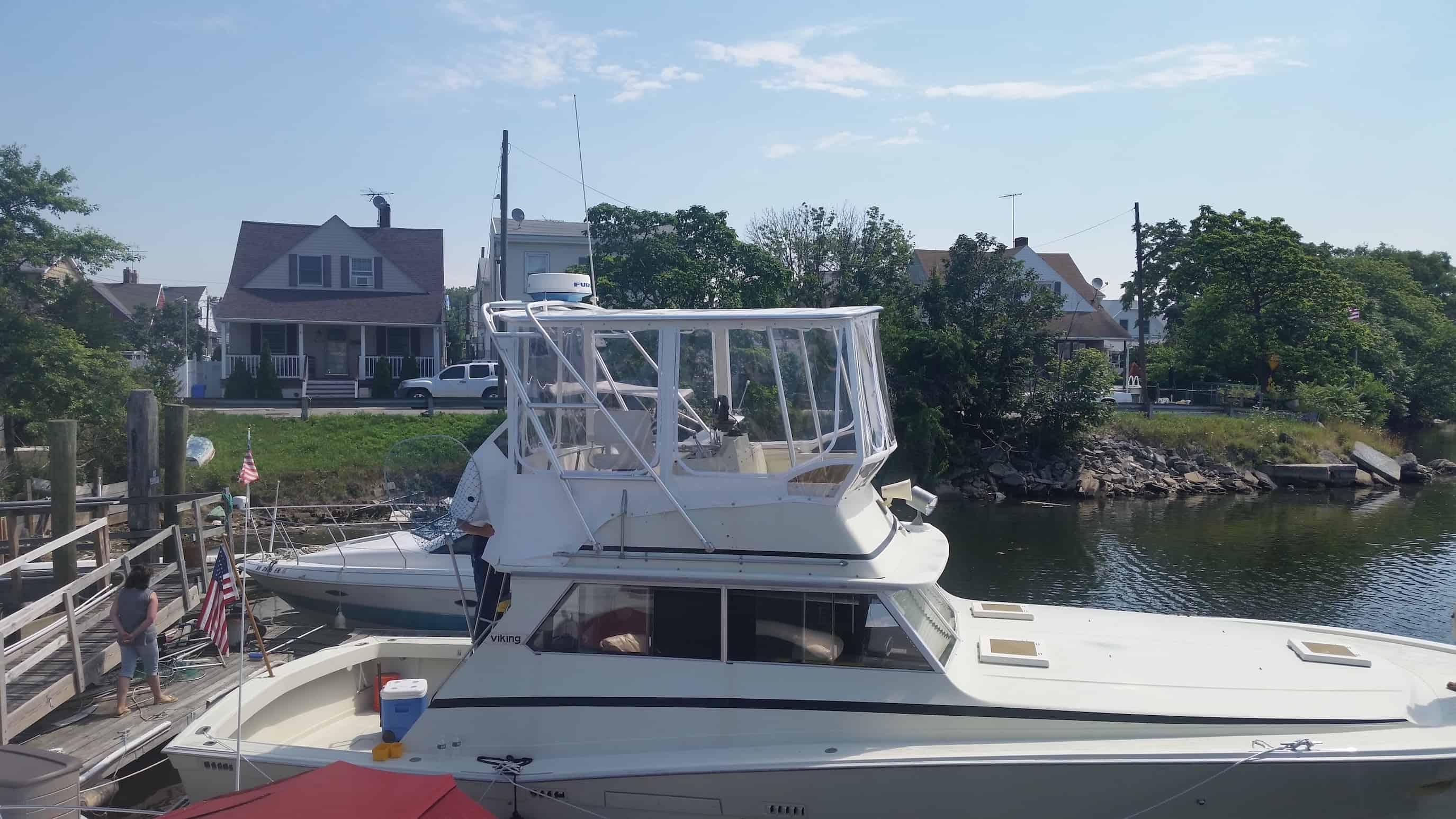Atlantic Towers Top installed on a Viking boat docked near residential homes by a waterway on a sunny day.