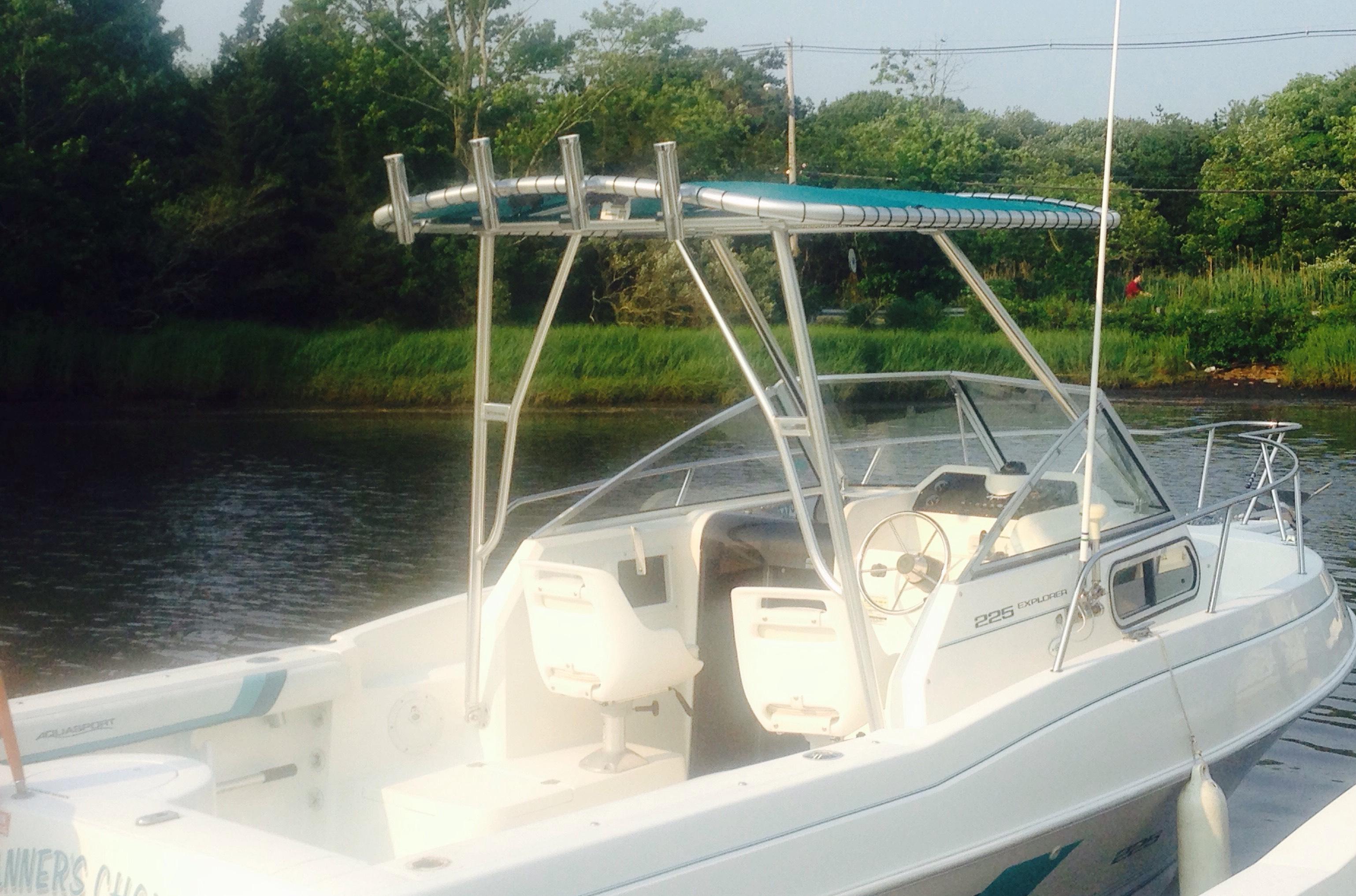 Atlantic Towers Top installed on an Aquasport boat, featuring two seats and a view of the water and greenery.
