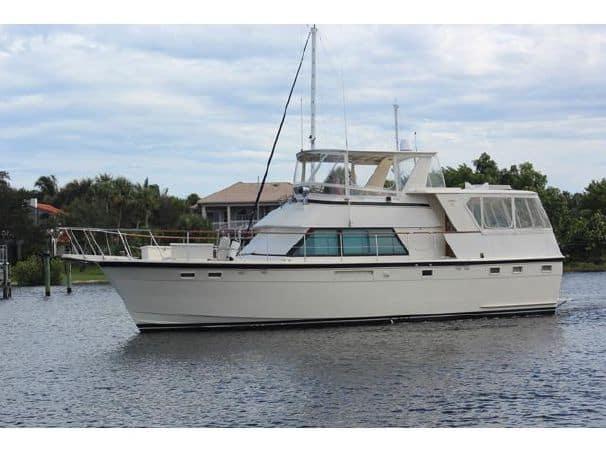 Atlantic Towers Top installed on a Hattaras boat, moored on a calm waterway with lush greenery in the background.