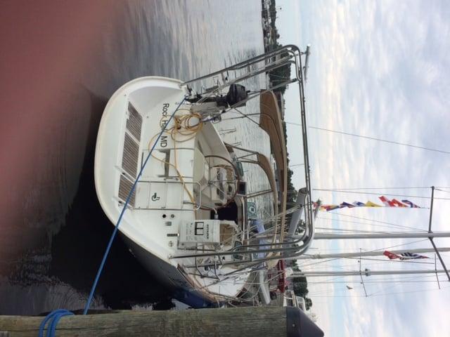 Beneteau boat docked with Atlantic Towers arch installed, showing cockpit, steering wheel, and rigging equipment.