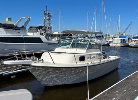 White Parker boat docked at marina with Atlantic Towers Top installed over the cabin and other boats in the background.