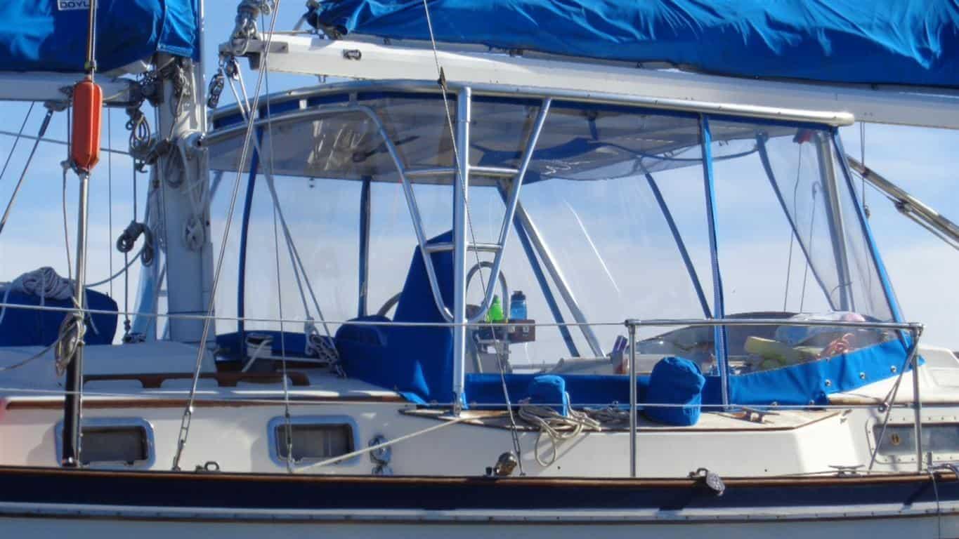 Whitbey sailboat with Atlantic Towers Top installed over the cockpit area with blue protective covers and clear panels.