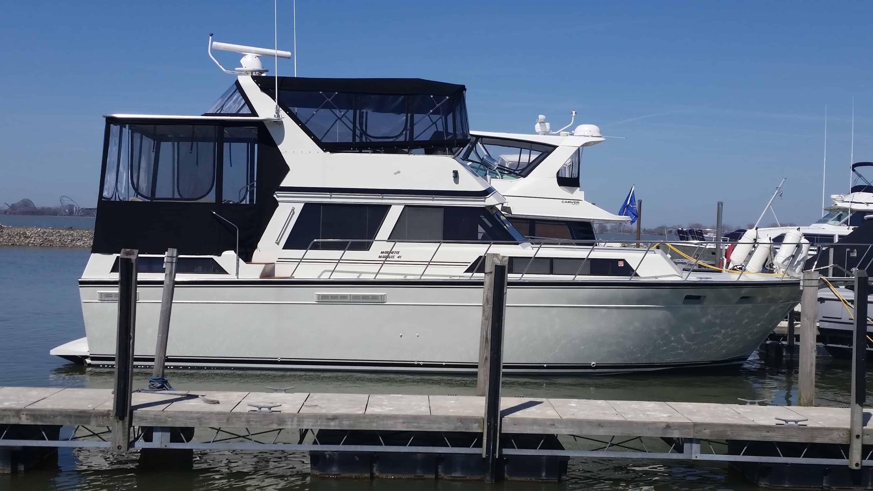 Atlantic Towers Aft Deck Top on a boat docked at a marina, featuring a white hull and black canvas around the helm.