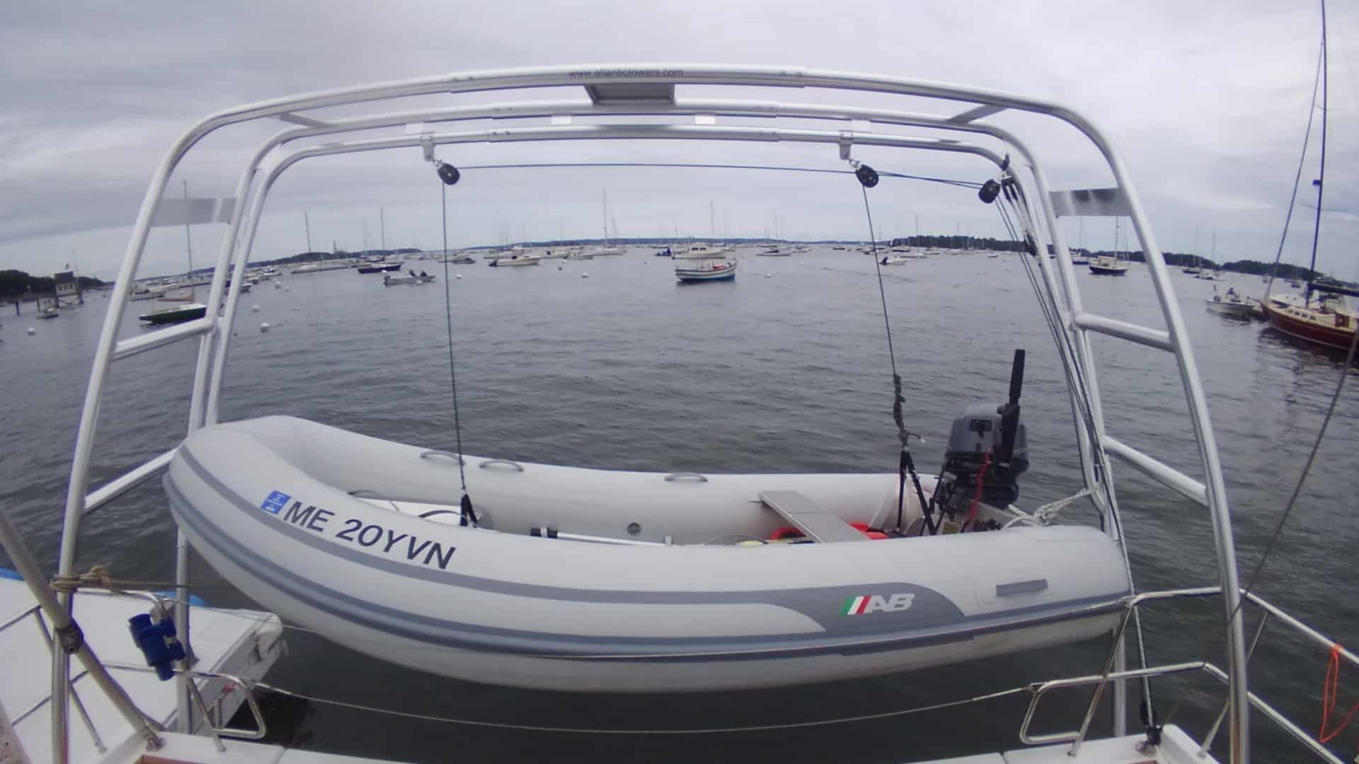 Atlantic Towers arch mounted on a Hanse boat with an inflatable dinghy suspended over water in a harbor.