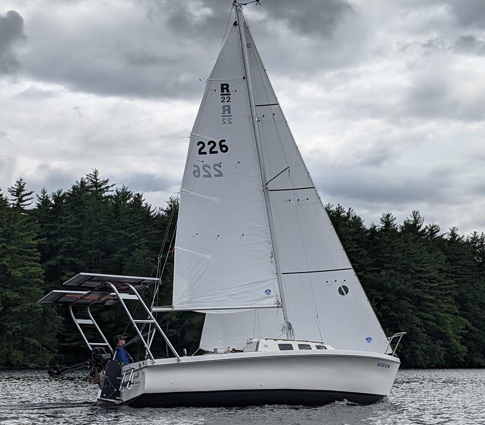 Atlantic Towers Arch installed on a white sailboat moving through calm waters with trees in the background.