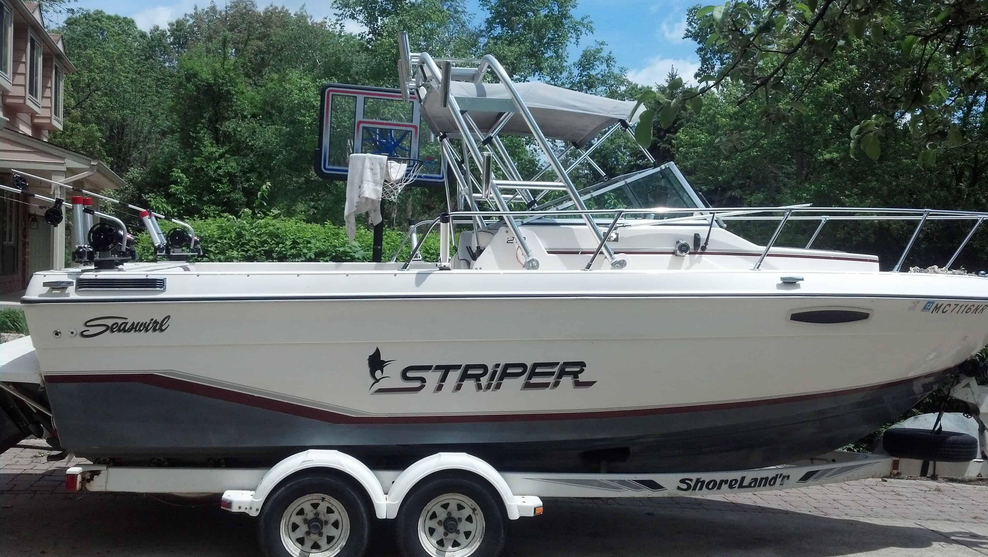 Atlantic Towers Top installed on a Seaswirl Striper boat parked on a trailer in a residential area.