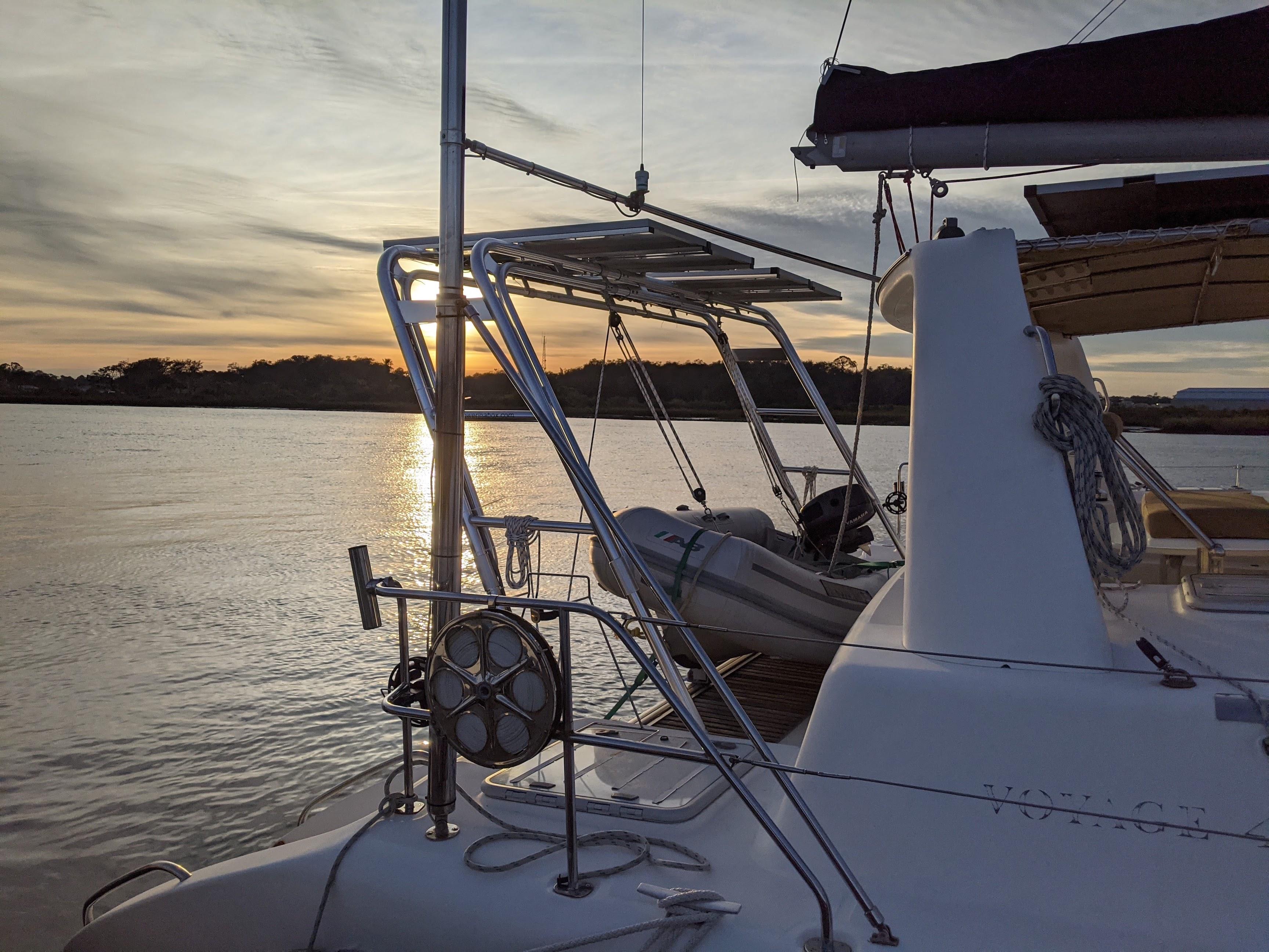 Atlantic Towers Arch installed on the stern of a Voyage boat at sunset with a small inflatable dinghy secured alongside.