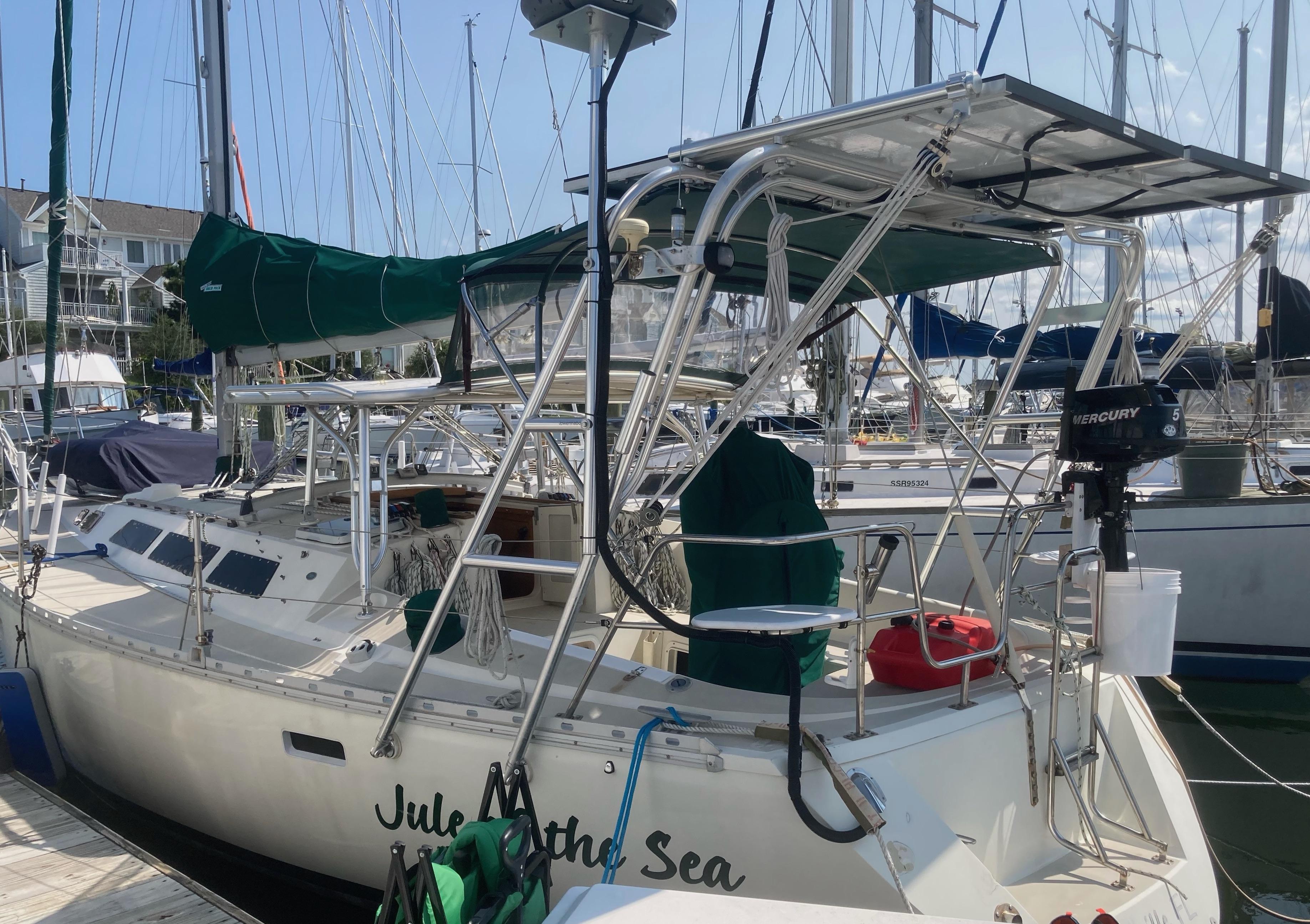 Atlantic Towers Arch installed on an O'Day boat, showcasing a sunny marina setting with equipment and green covers.