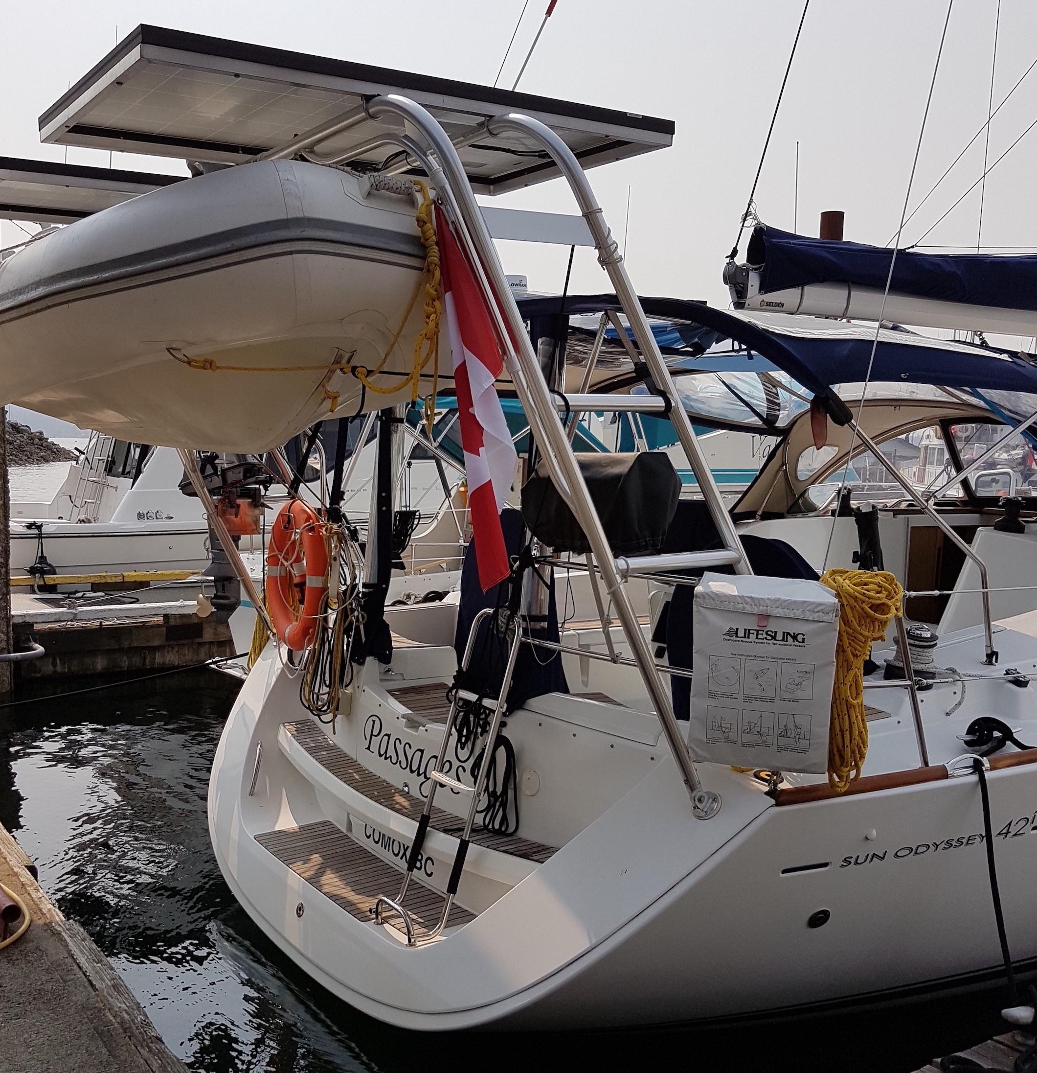 Atlantic Towers Arch installed on a Jeanneau boat at the marina, supporting a dinghy above the stern.