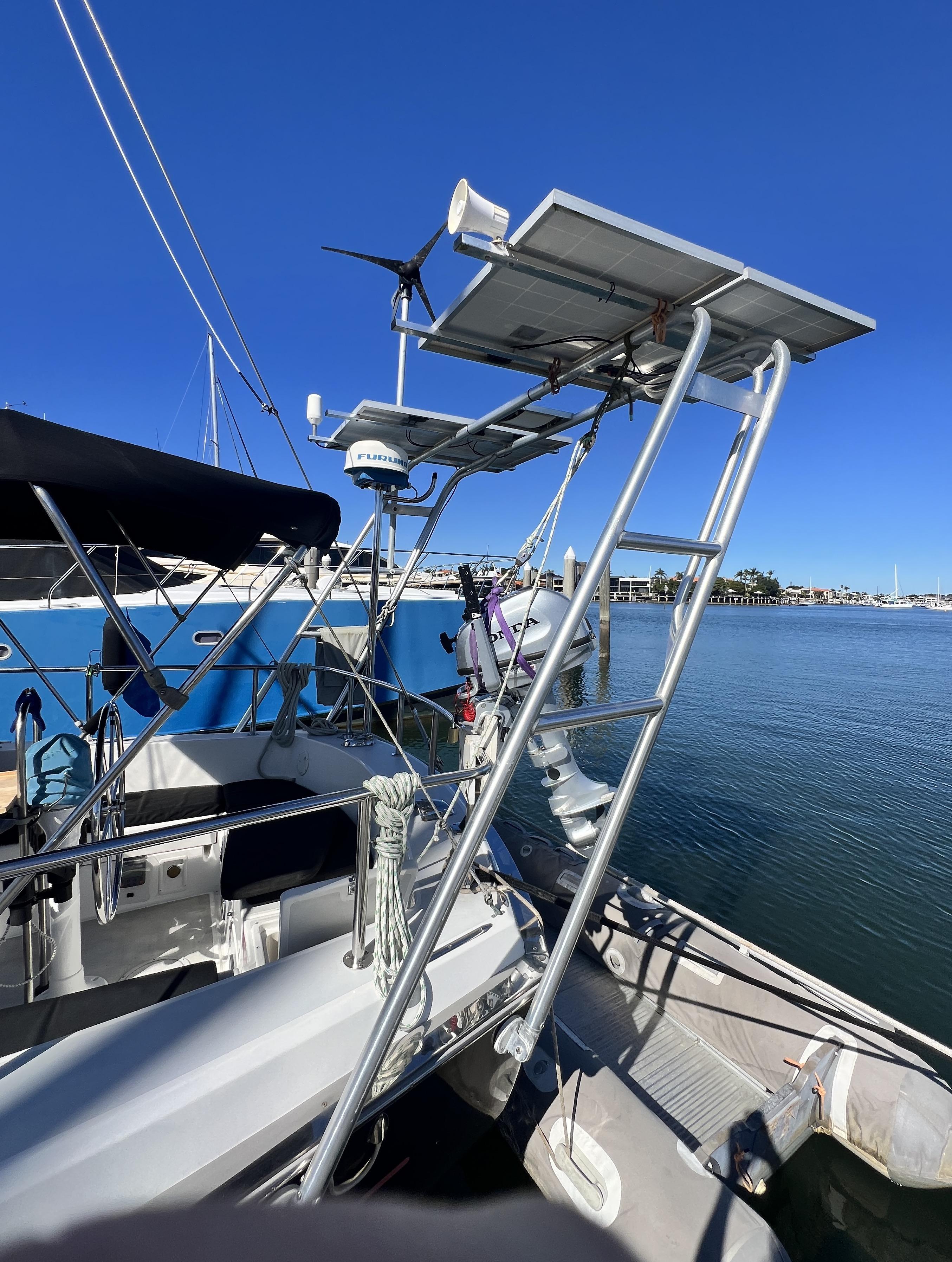 Atlantic Towers Arch mounted on a Pearson sailboat with solar panels, a wind turbine, and an outboard motor at the marina.