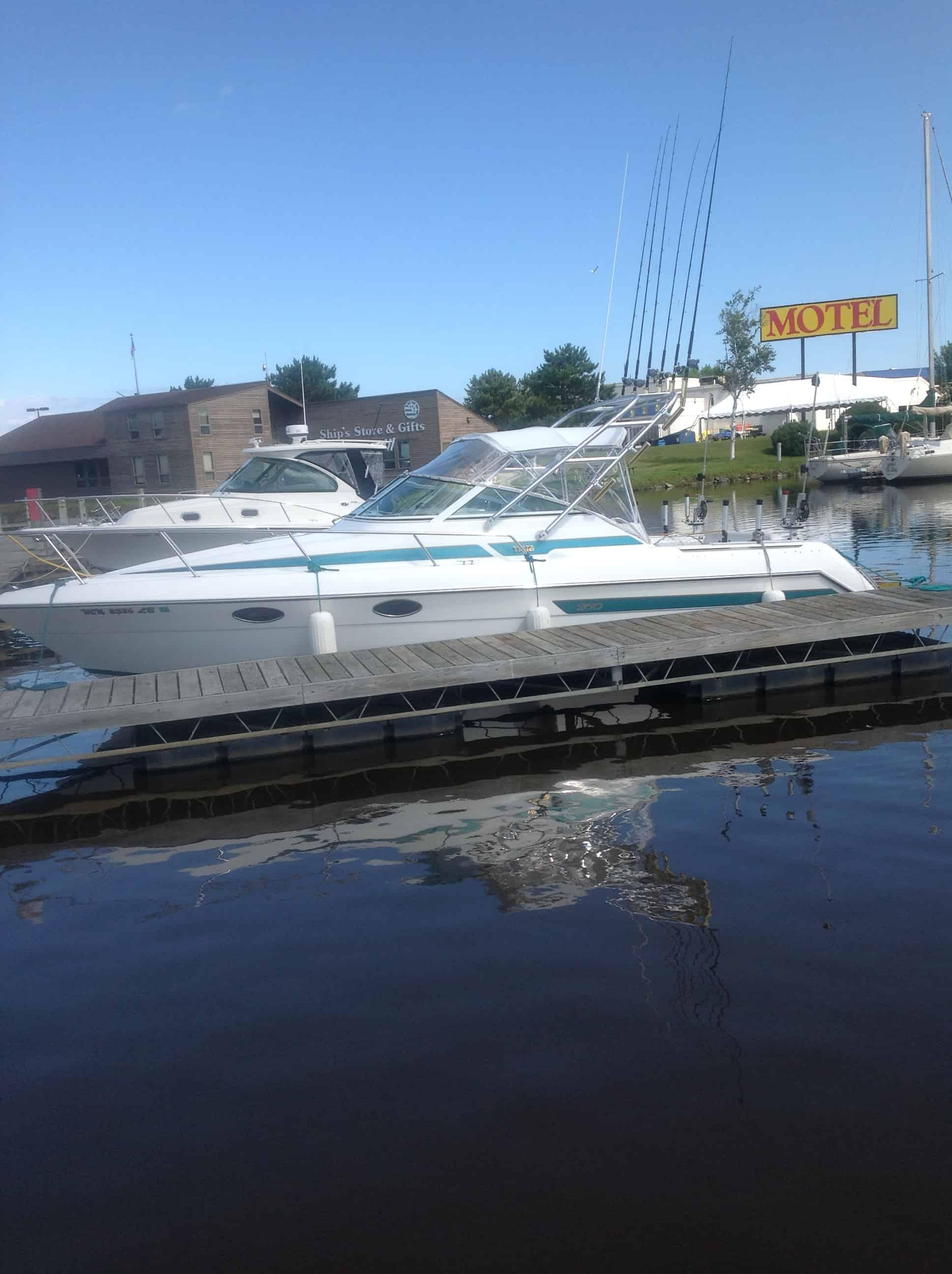 Atlantic Towers Arch installed on a Tiara boat docked on calm water near a motel and shops.