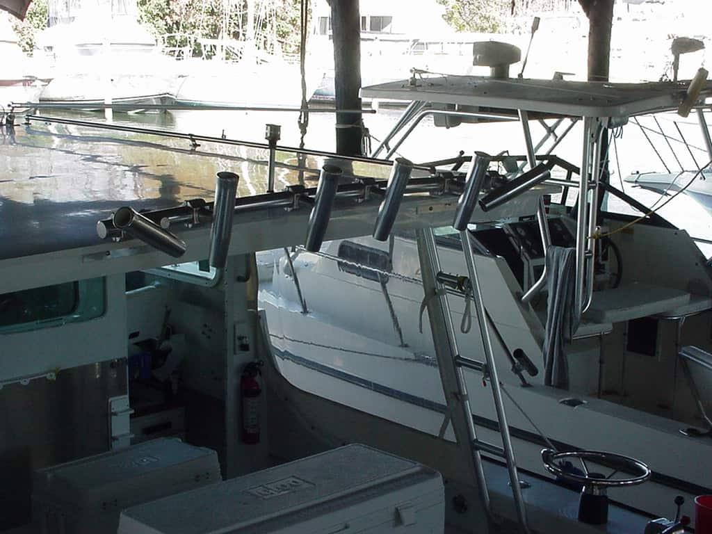 Atlantic Towers Accessories mounted on a boat's upper frame with multiple angled rod holders above cockpit area in a covered dock.