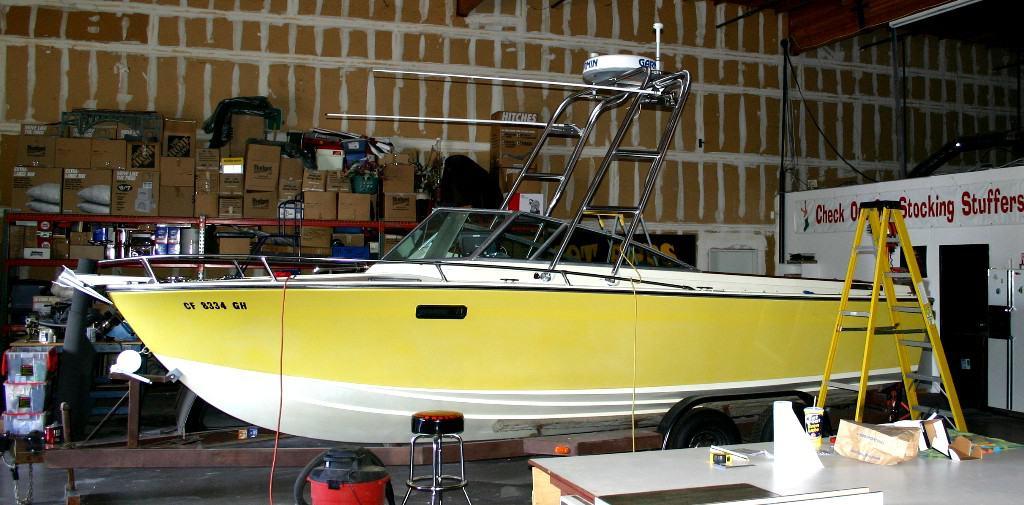 Yellow and white Formula 233 Thunderbird boat with Atlantic Towers Arch installed, inside a storage or workshop area.