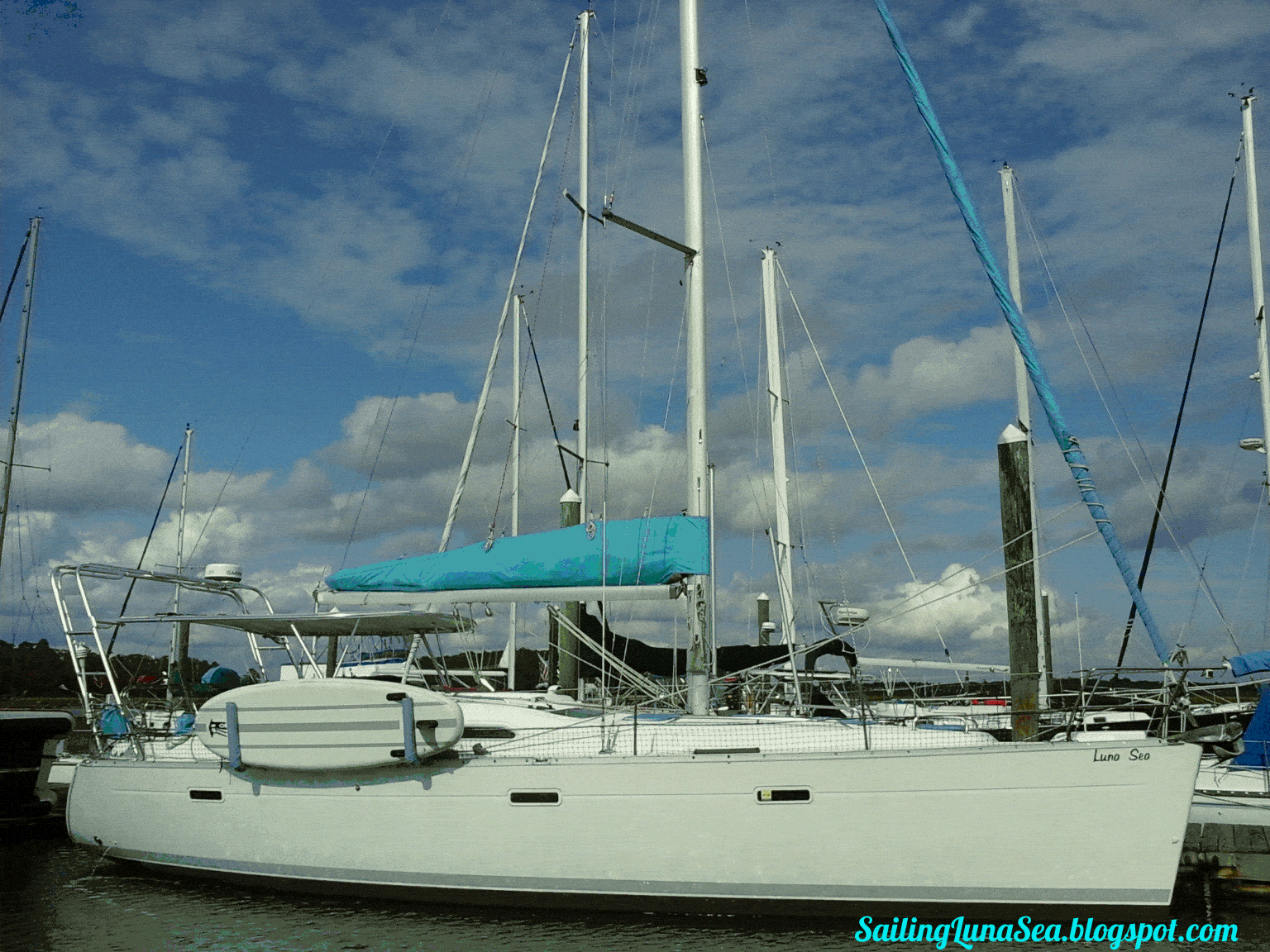 Beneteau sailboat docked at marina with Atlantic Towers Top installed on the deck under clear sky.