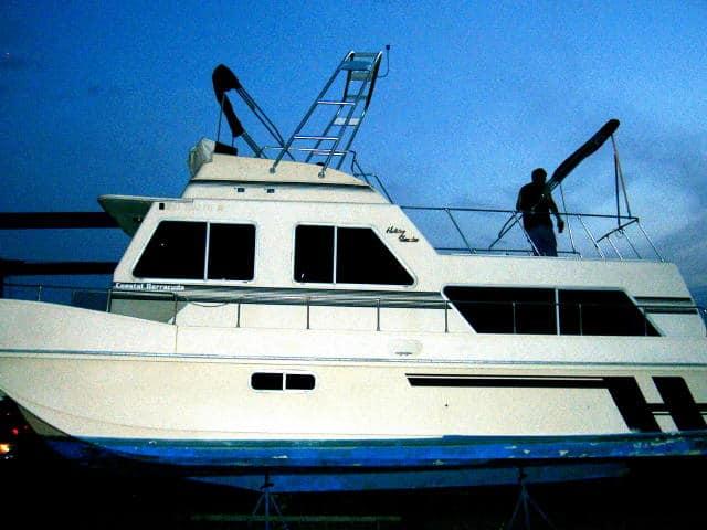 Atlantic Towers Arch installed on a Holiday Mansion 38 Coastal Barracuda boat, shown during twilight with a person onboard.