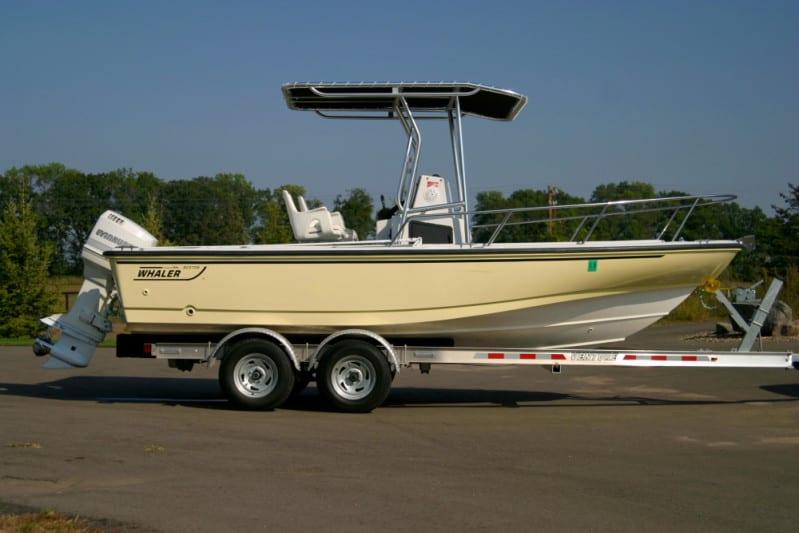 Side view of a boat on a trailer fitted with an Atlantic Towers T-Top frame and dual outboard motors in an outdoor setting