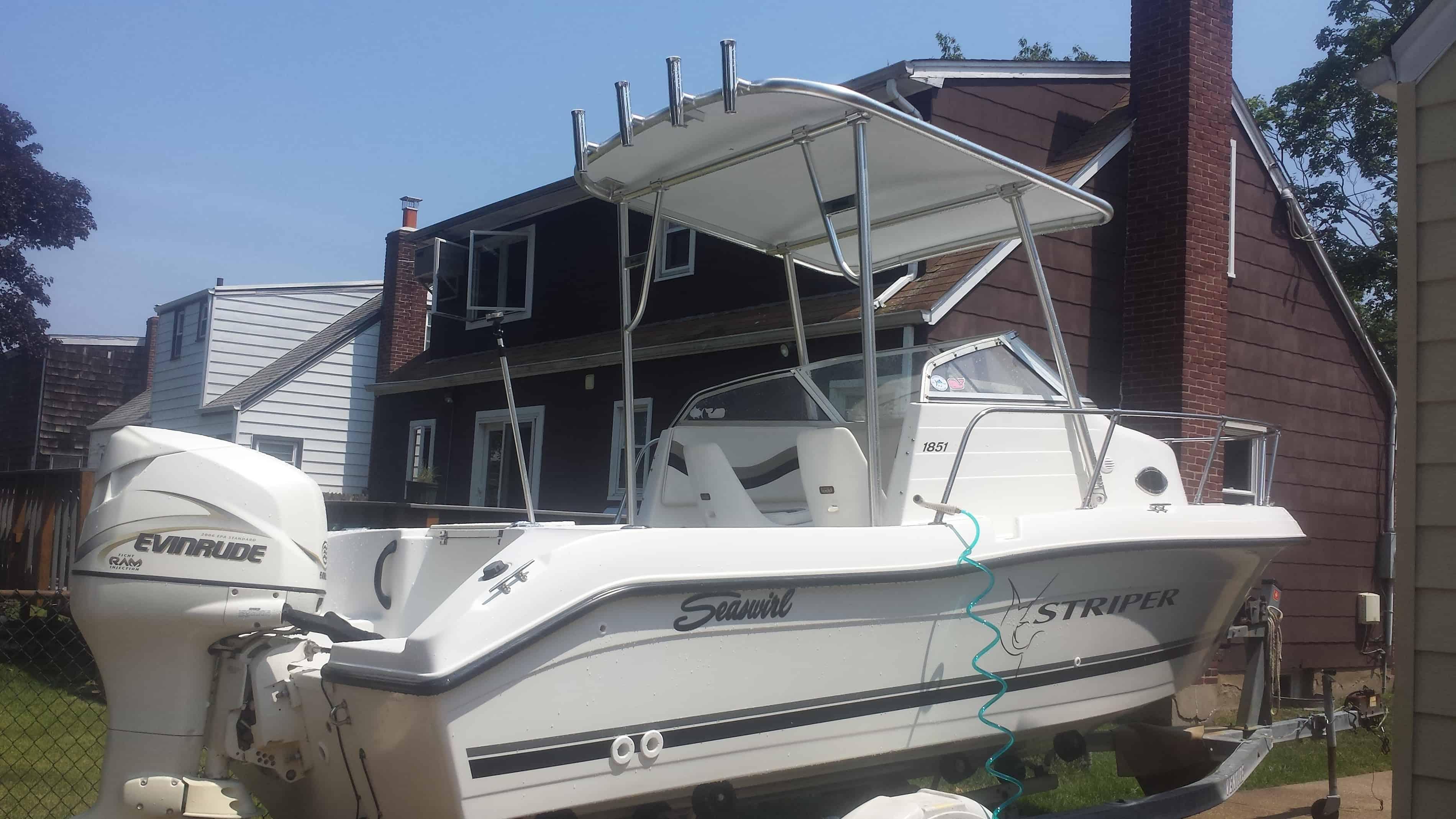 Atlantic Towers arch mounted on a white Seawirl Striper boat parked in a residential driveway with houses in the background.