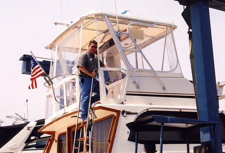 A person stands on a ladder next to the Atlantic Towers Top installed on an Egg Harbor 35 Sport Fisherman boat.