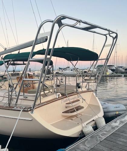 Atlantic Towers Arch installed on an Island Packet boat, moored at a marina with sailboats in the background.
