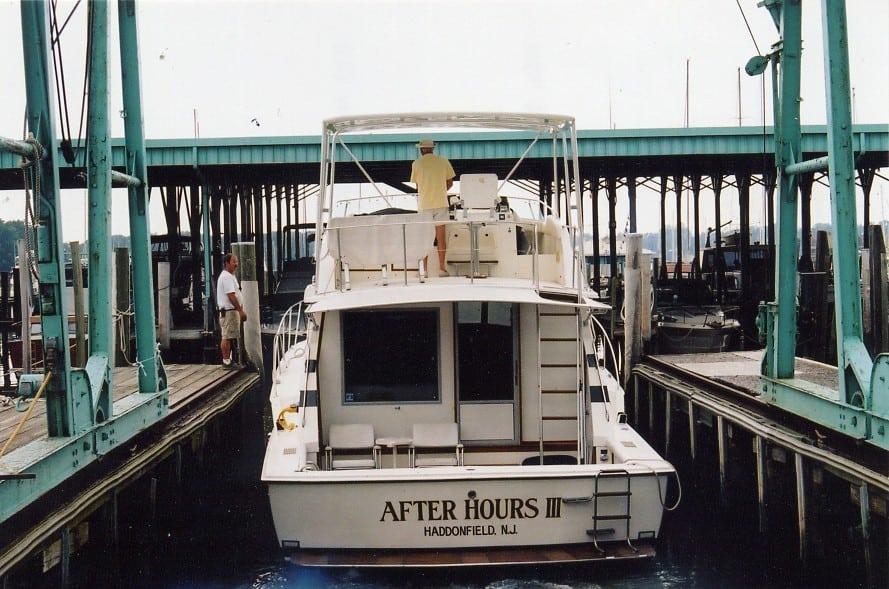 Atlantic Towers Top installed on a Bertram 446 Convertible boat, docked at a marina with two people nearby.