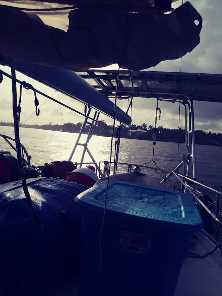 View of the Atlantic Towers Arch installed on a boat, with storage containers and a scenic water backdrop.