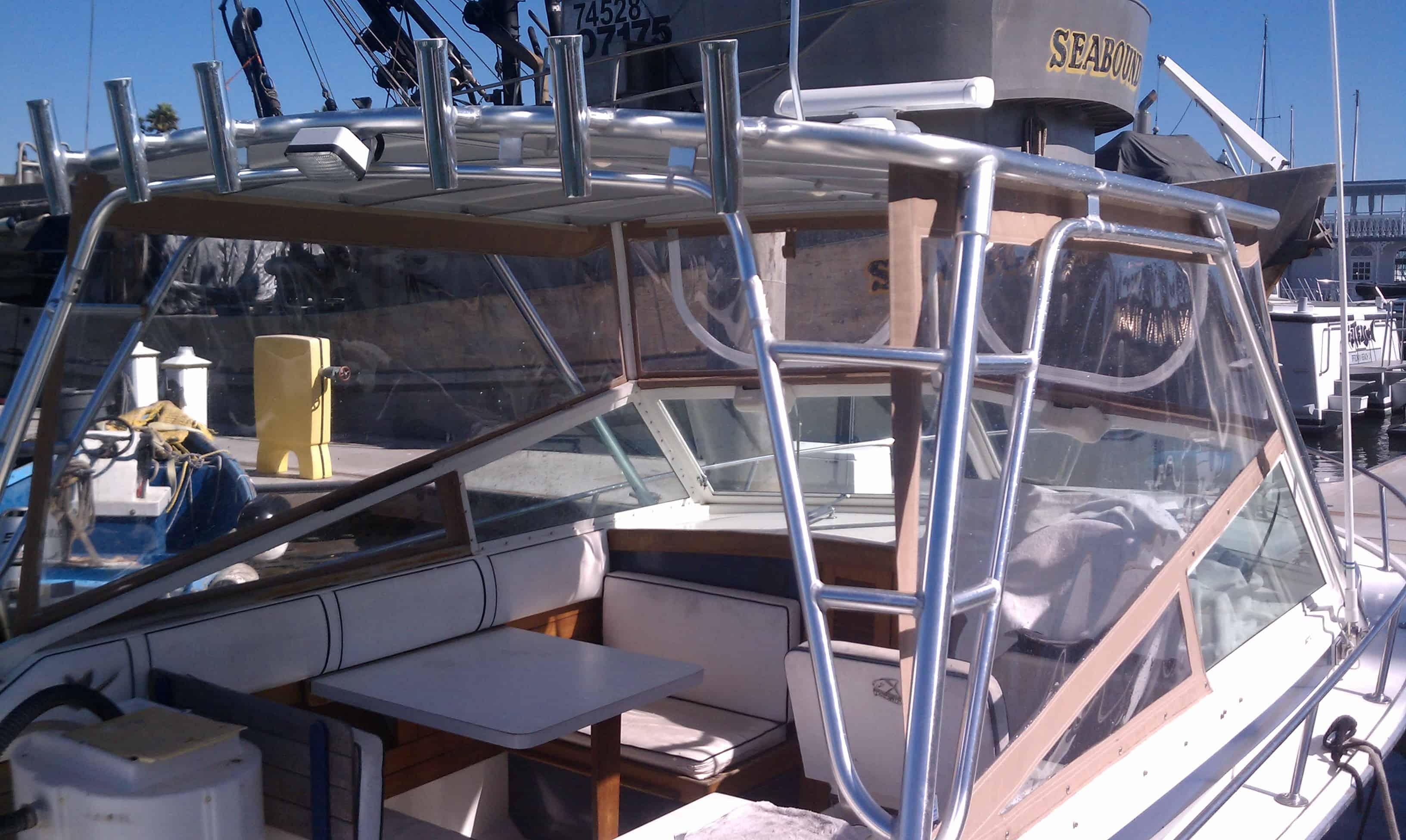 Cockpit view of Bertram 26 Sport Convertible boat with installed Atlantic Towers Top aluminum frame and clear enclosure panels.