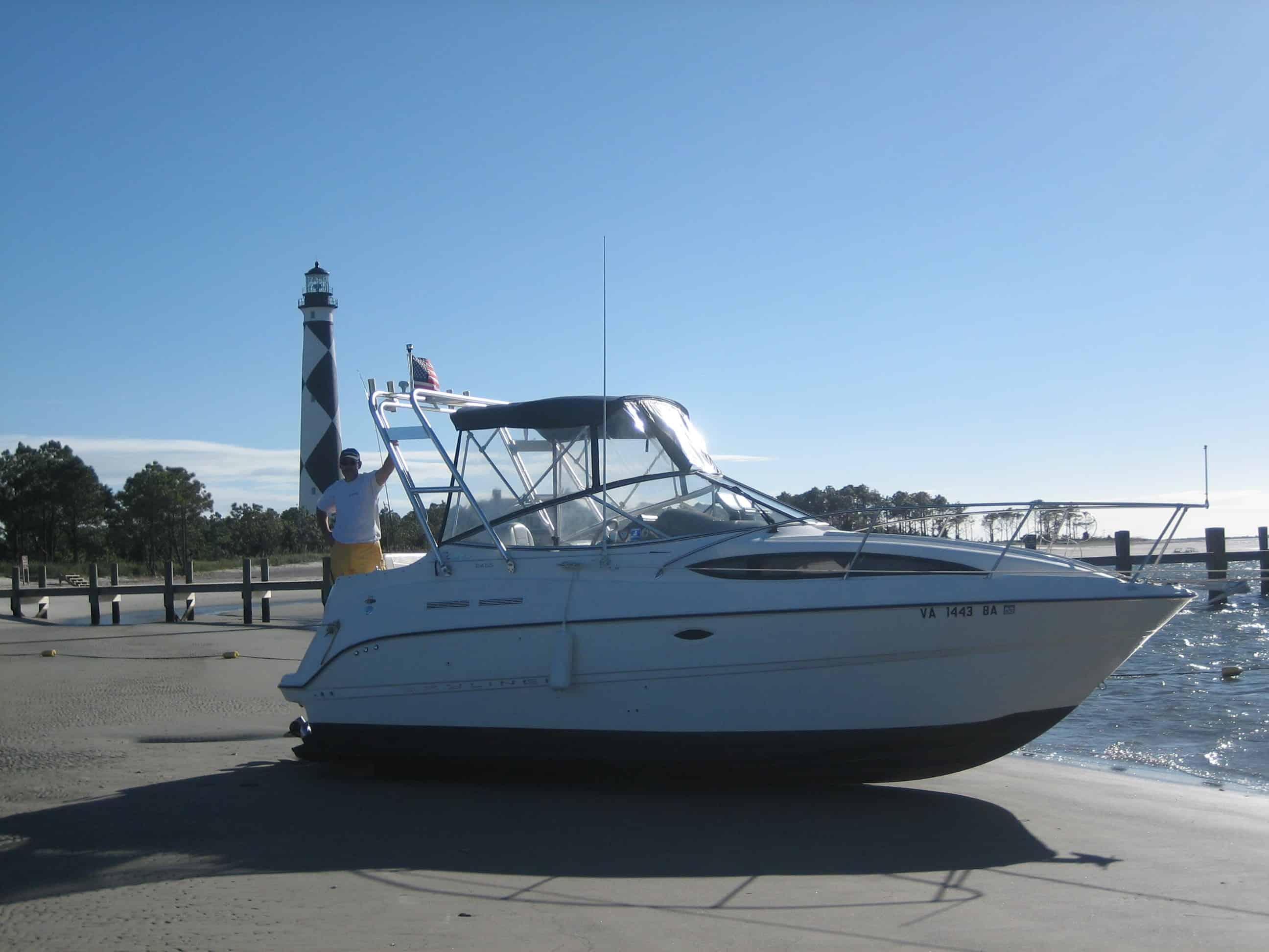 Atlantic Towers Arch on a Bayliner 245 Ciera boat at the shore with a lighthouse in the background.