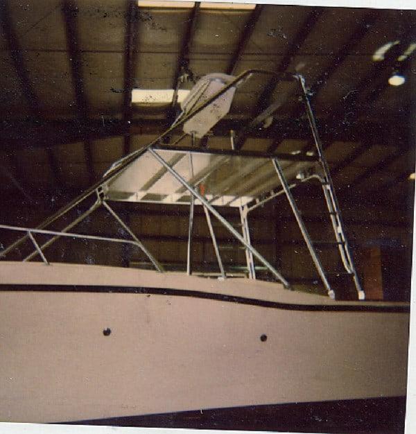 Atlantic Towers Tuna Tower installed on side of Mako 285 boat inside an indoor storage facility under metal roof beams.