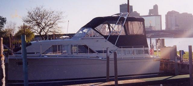 Chris Craft 35 Catalina boat docked with installed Atlantic Towers Arch and a black canvas canopy in a city harbor.