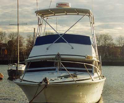 Atlantic Towers Top installed on a Bertram 28 Flybridge Cruiser moored on a calm waterway with trees in the background.