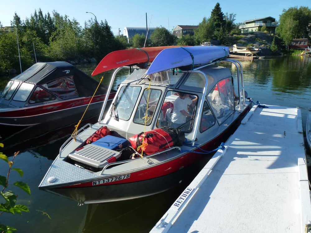 Hewes 220 Ocean Pro boat docked with two kayaks secured on the Atlantic Towers Arch in a calm marina.