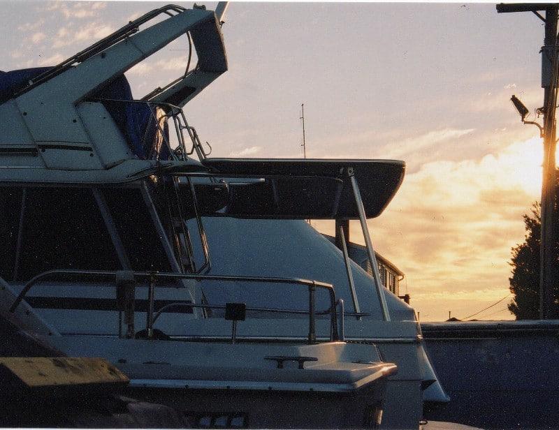 Side view of Bayliner 3270 MY boat at sunset with Atlantic Towers Cockpit Sun Shade installed above the cockpit area