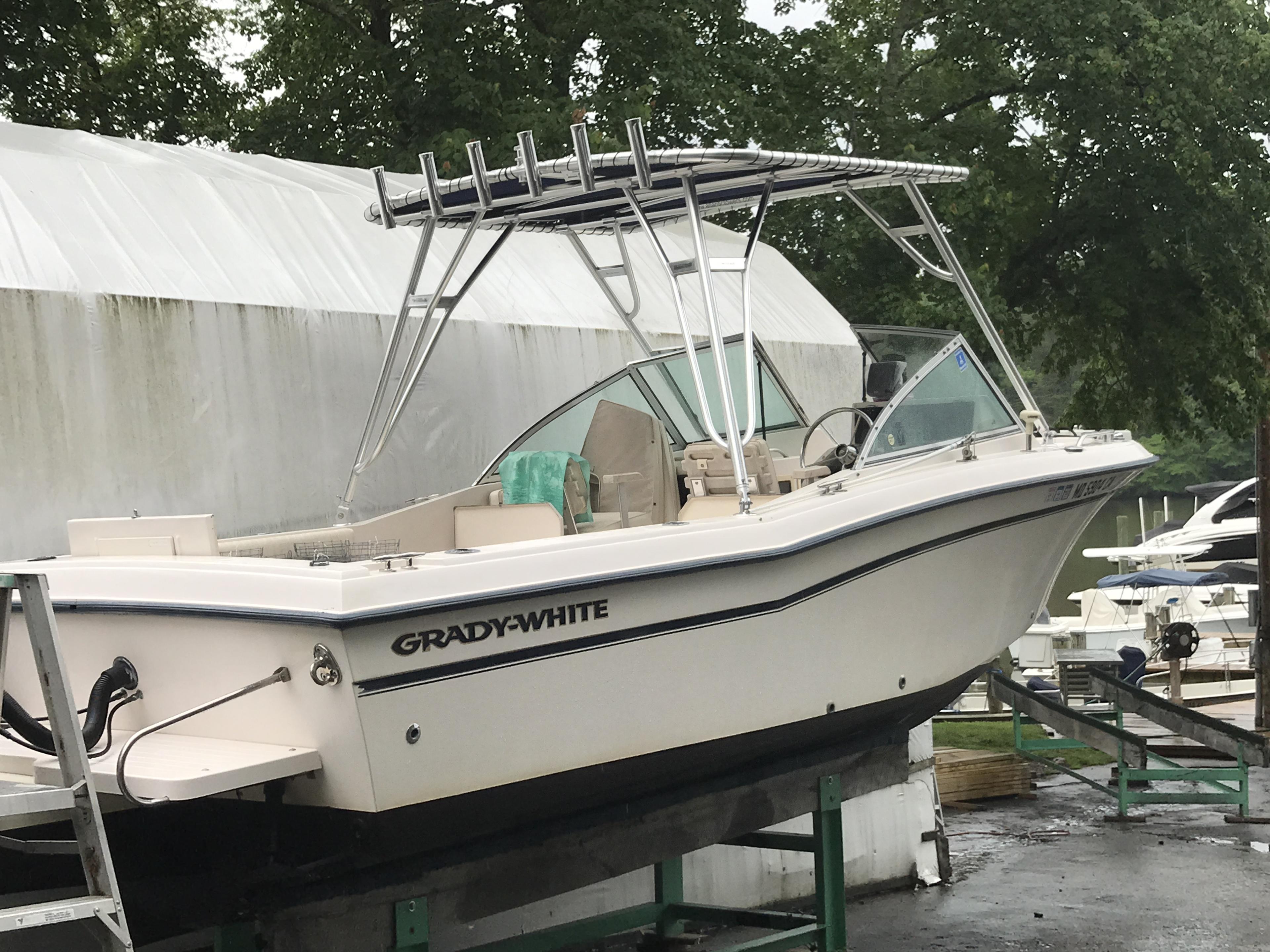 Grady White boat with installed Atlantic Towers Top, showing aluminum frame and rod holders on a boat trailer near marina.