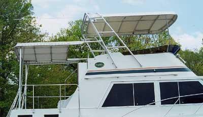 Atlantic Towers boat canopy installed on a white boat, with a backdrop of green trees and a blue sky.
