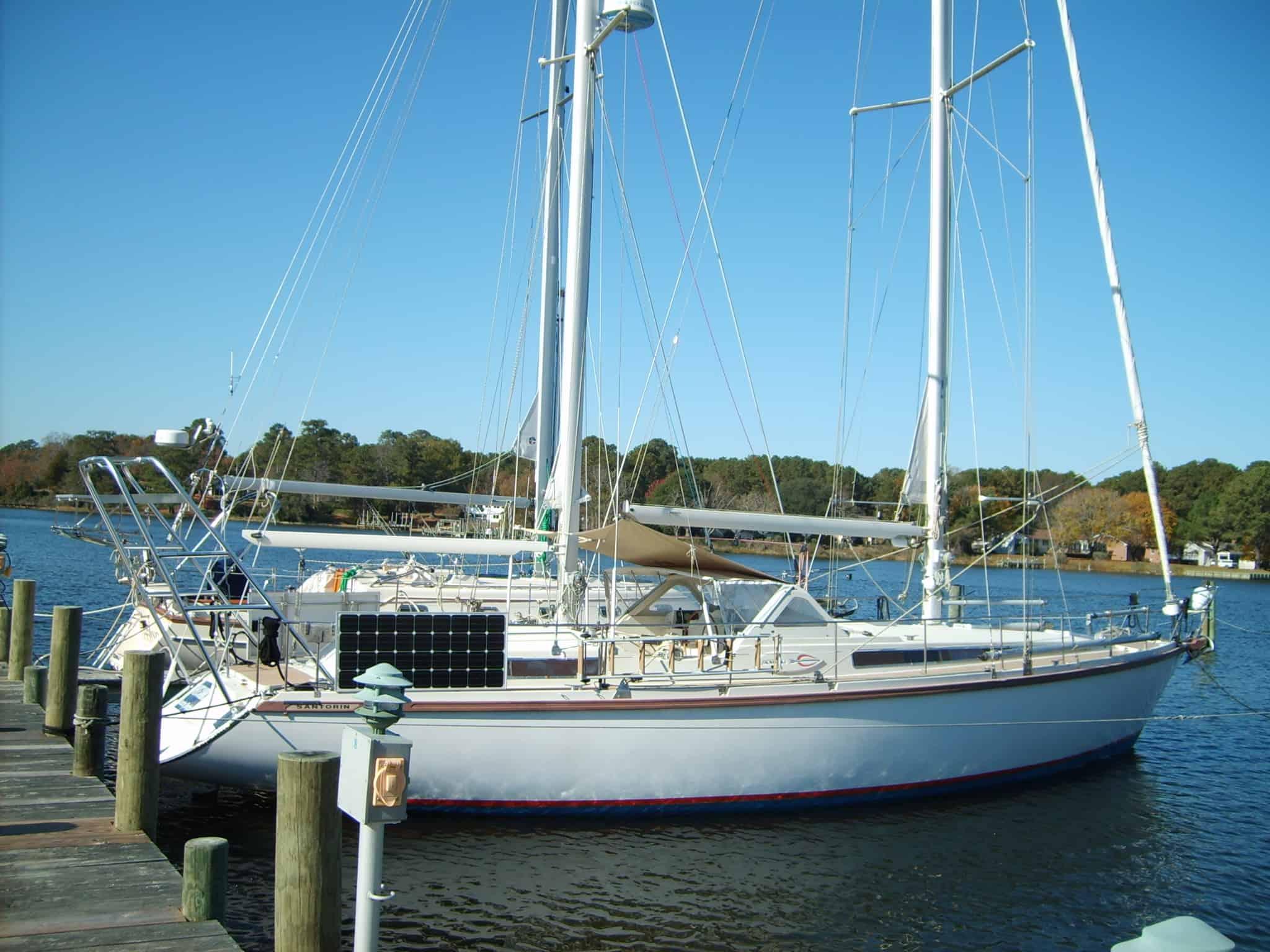 Atlantic Towers Arch installed on an Amel sailboat at a marina, surrounded by calm water and trees in the background.
