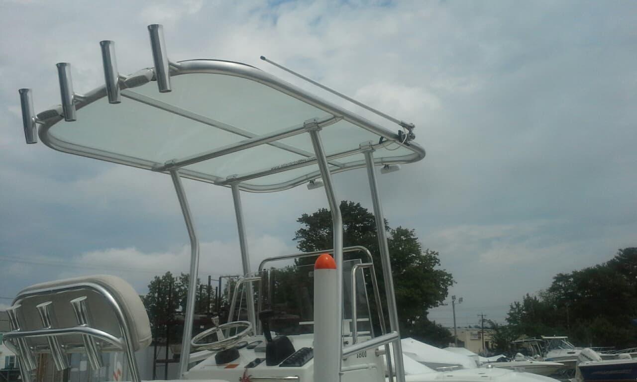Atlantic Towers T-Top mounted on a boat, featuring a clear canopy and rod holders, under a cloudy sky.
