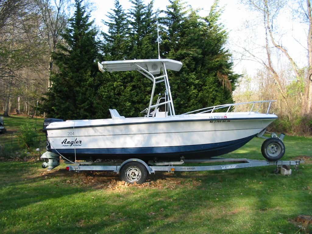 Atlantic Towers boat on a trailer in a grassy area, surrounded by trees, with the name "Angler" visible.