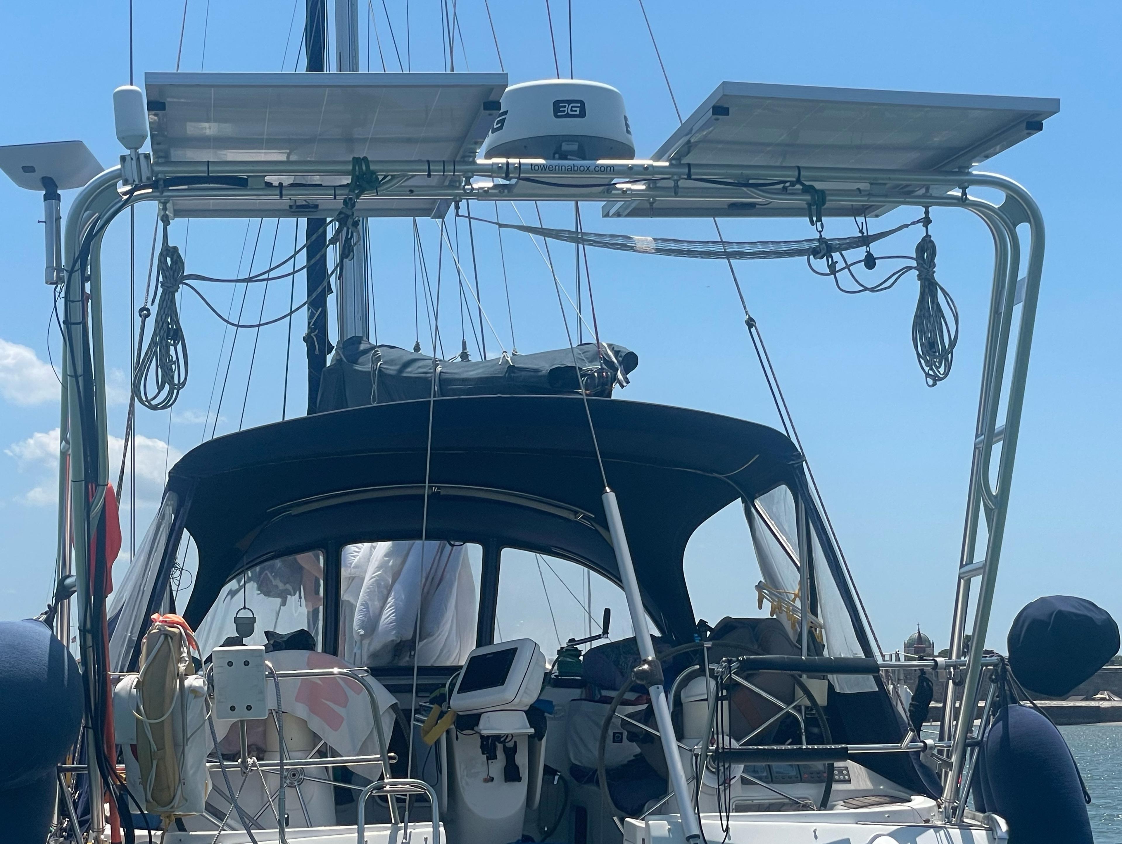 Atlantic Towers Arch mounted on a sailboat with solar panels and navigation equipment in a sunny marina setting.